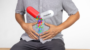 probiotics pill over a man's stomach that he's holding